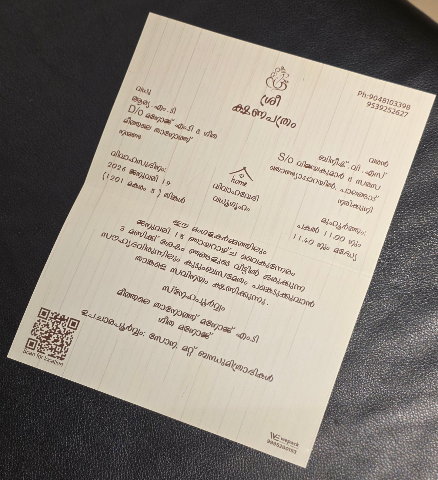 A white paper card with printed black text and a QR code, placed on a dark textured surface.