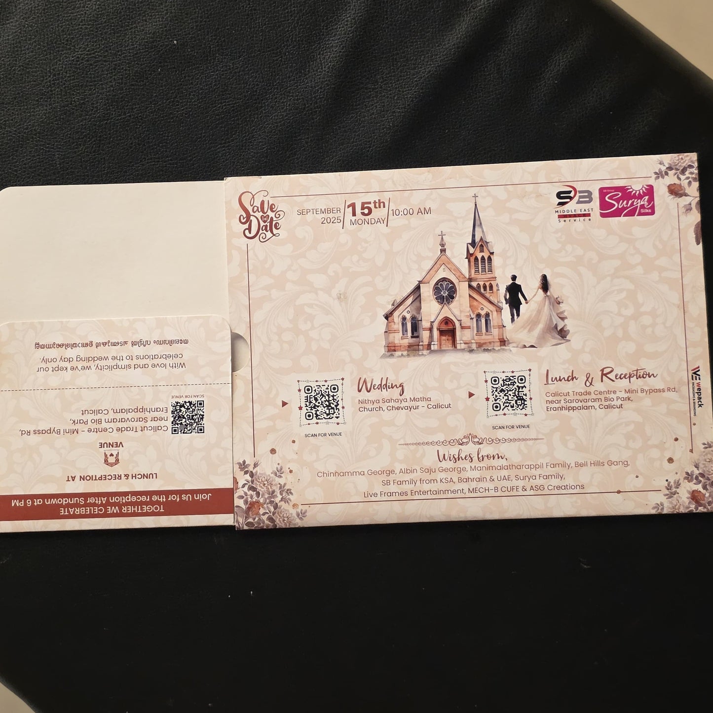 A printed invitation card or ticket with decorative borders, a castle illustration, QR codes, and text, placed on a dark fabric surface.