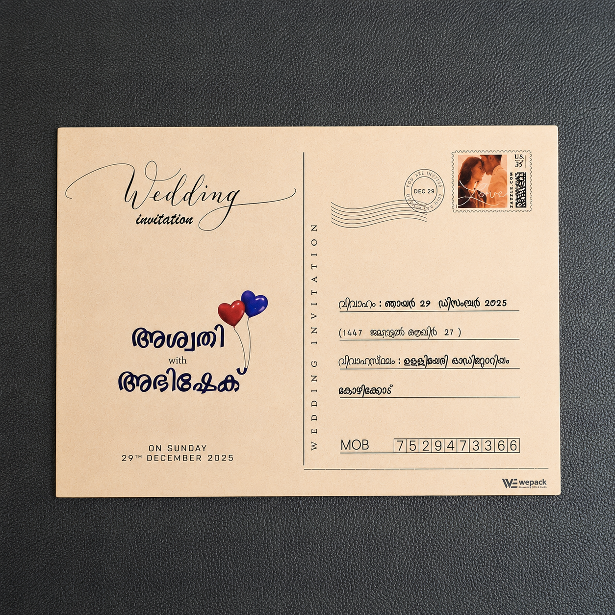 A vintage-style wedding invitation card designed like a postcard, printed on beige paper with elegant script, Malayalam text, a postage stamp illustration, and a small heart graphic, placed on a dark textured background.